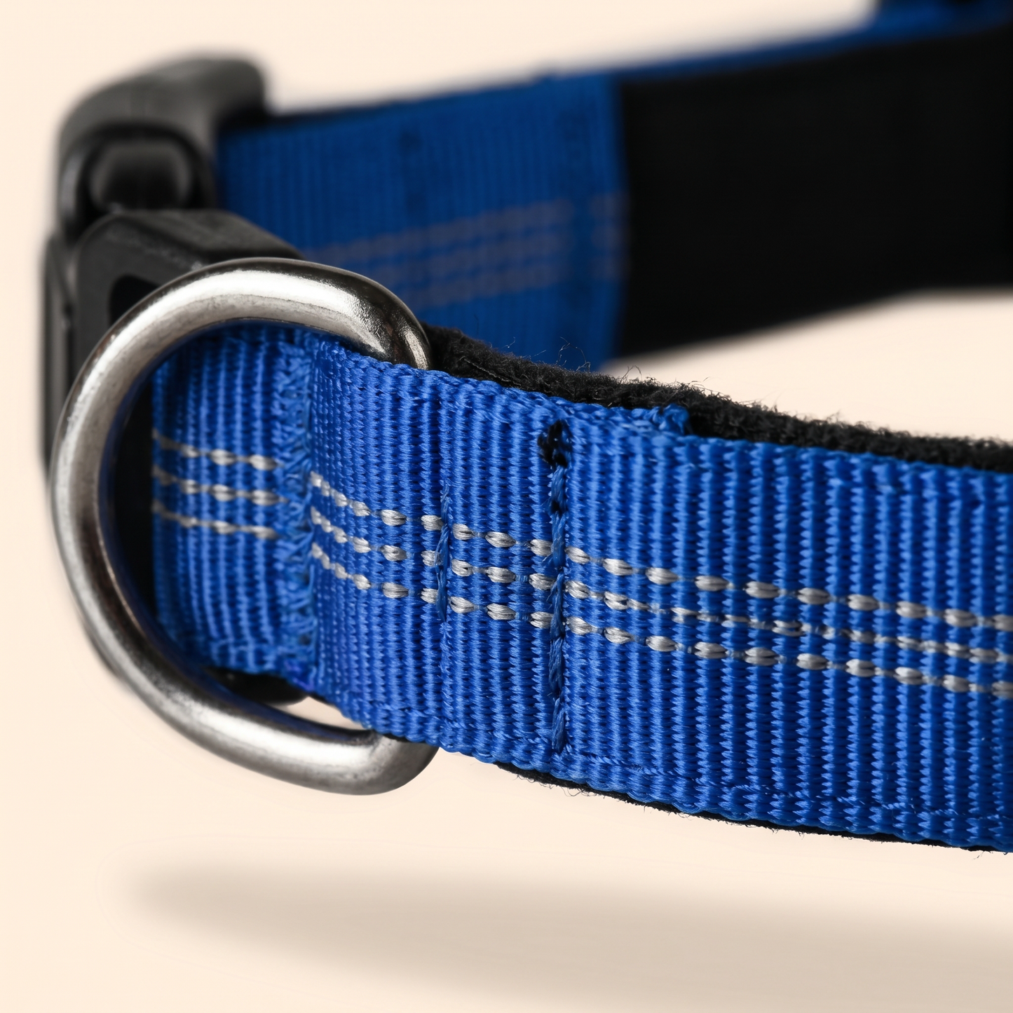 Close-up macro of the Joobello blue collar reflective double-stitching, woven nylon and sturdy metal D-ring