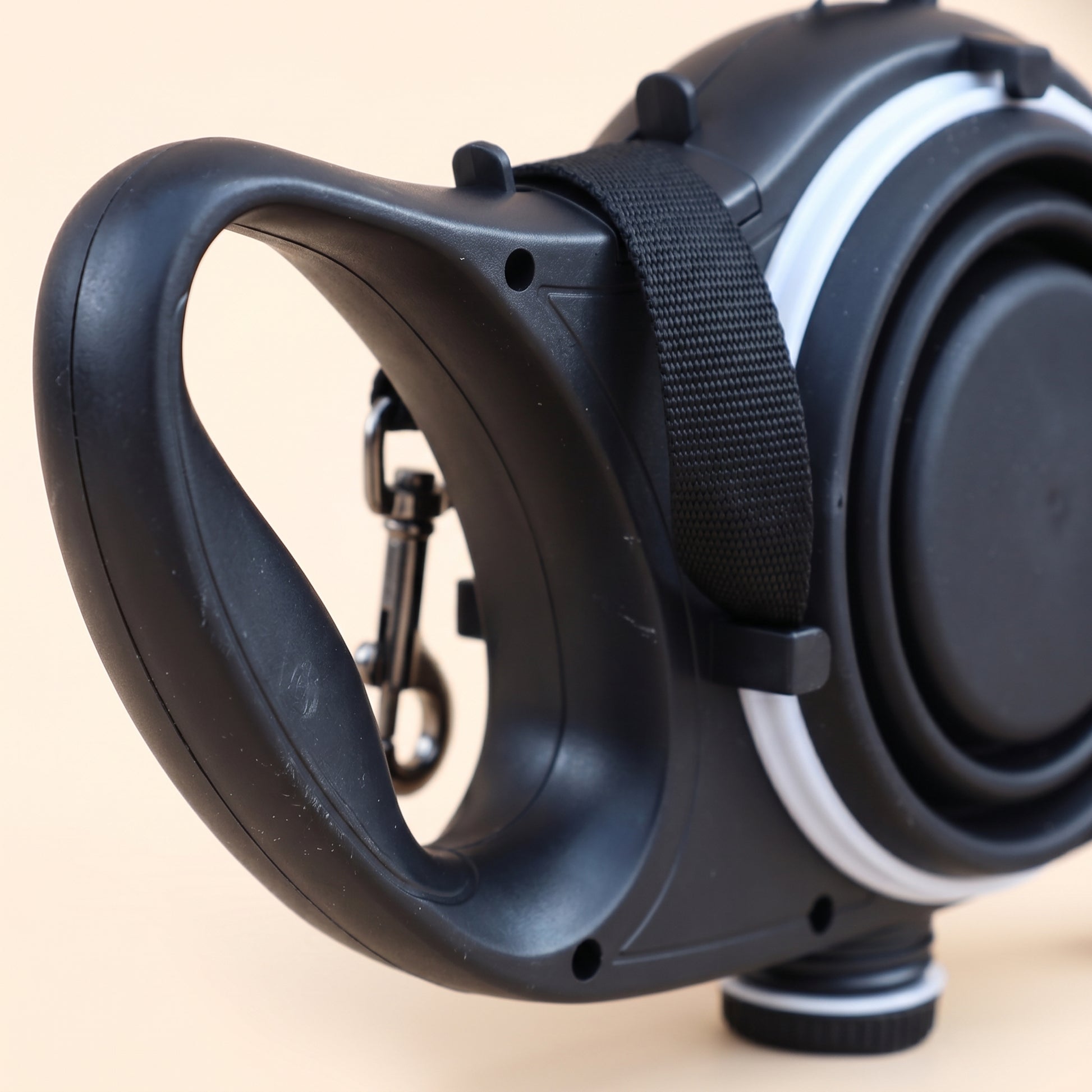 Close-up of the Joobello retractable dog leash ergonomic handle, metal leash clip and collapsible water bowl