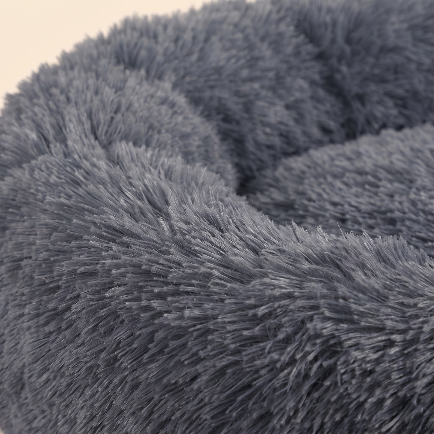 Close-up of the soft dark-gray faux-fur and raised cuddler rim of the Joobello calming donut dog bed