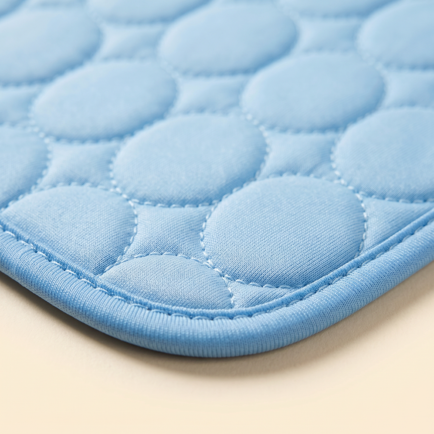 Close-up of the Joobello light-blue ice silk cooling mat quilted honeycomb surface and piped edge