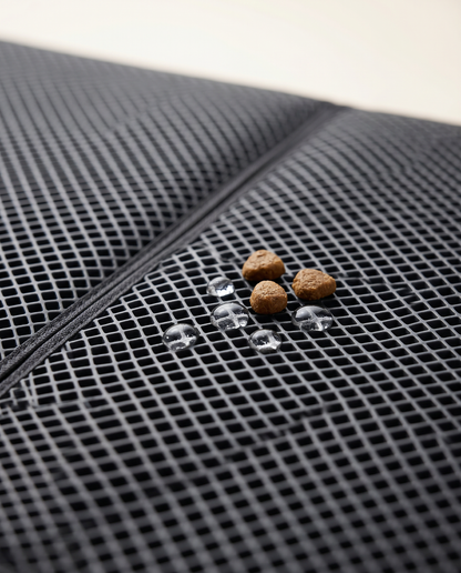 Close-up of the Joobello waterproof pet mat catching spilled kibble and water droplets in its honeycomb grid
